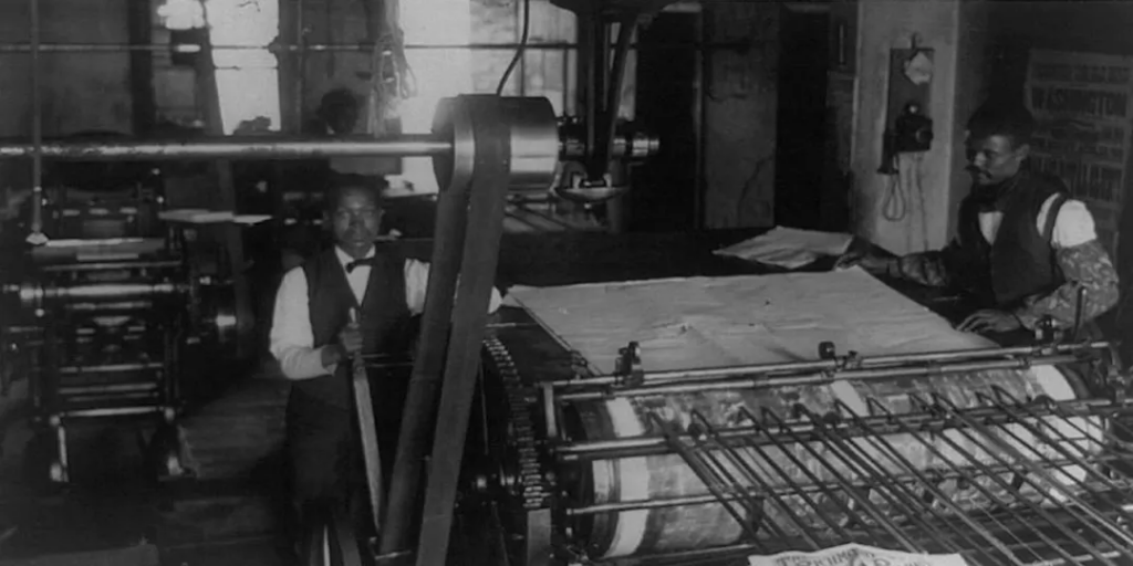 A Black gentleman running the newspaper printing press at Freedom Press, 1827