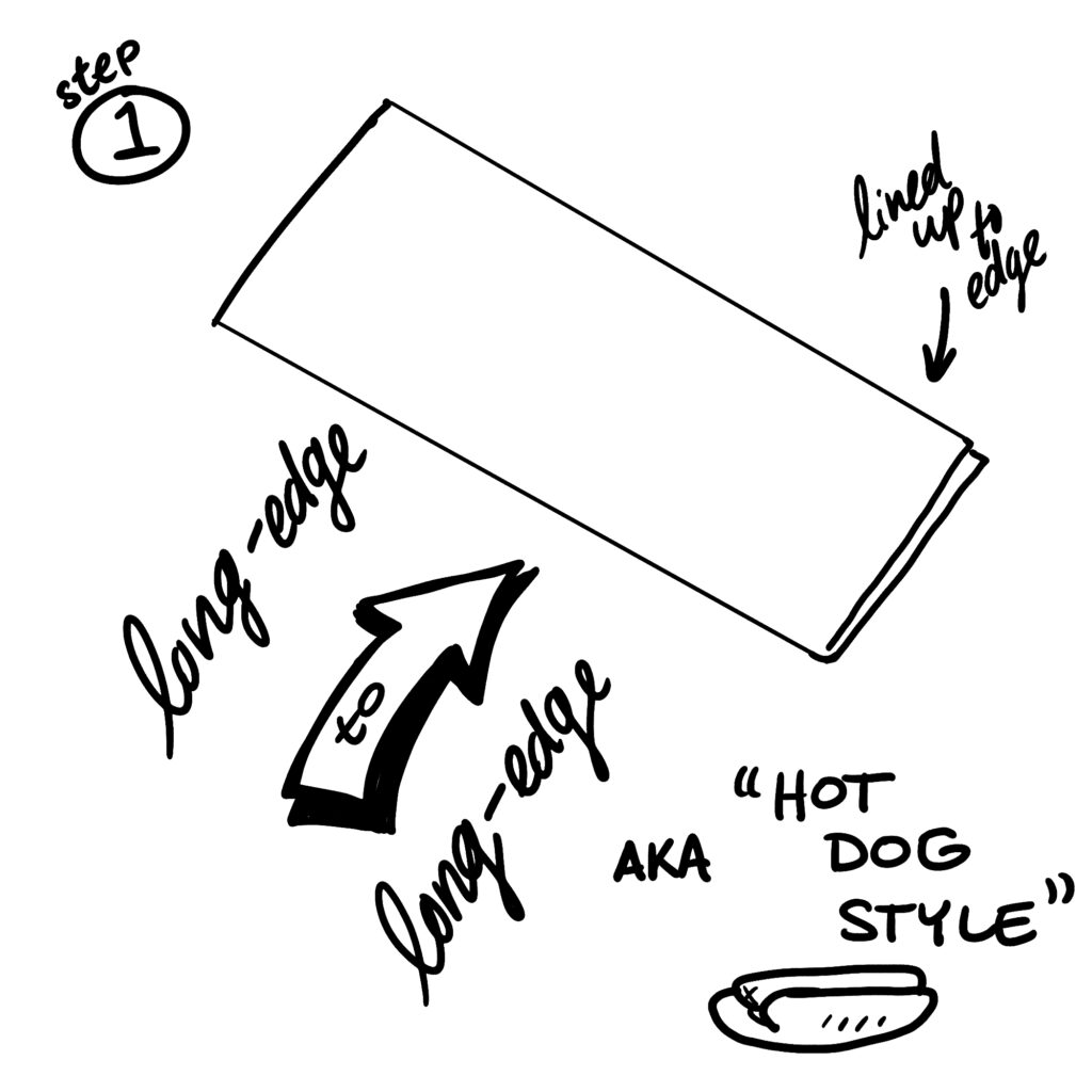 Step 1: Fold long edge to long edge AKA "hot dog style" (lined up to the edge)